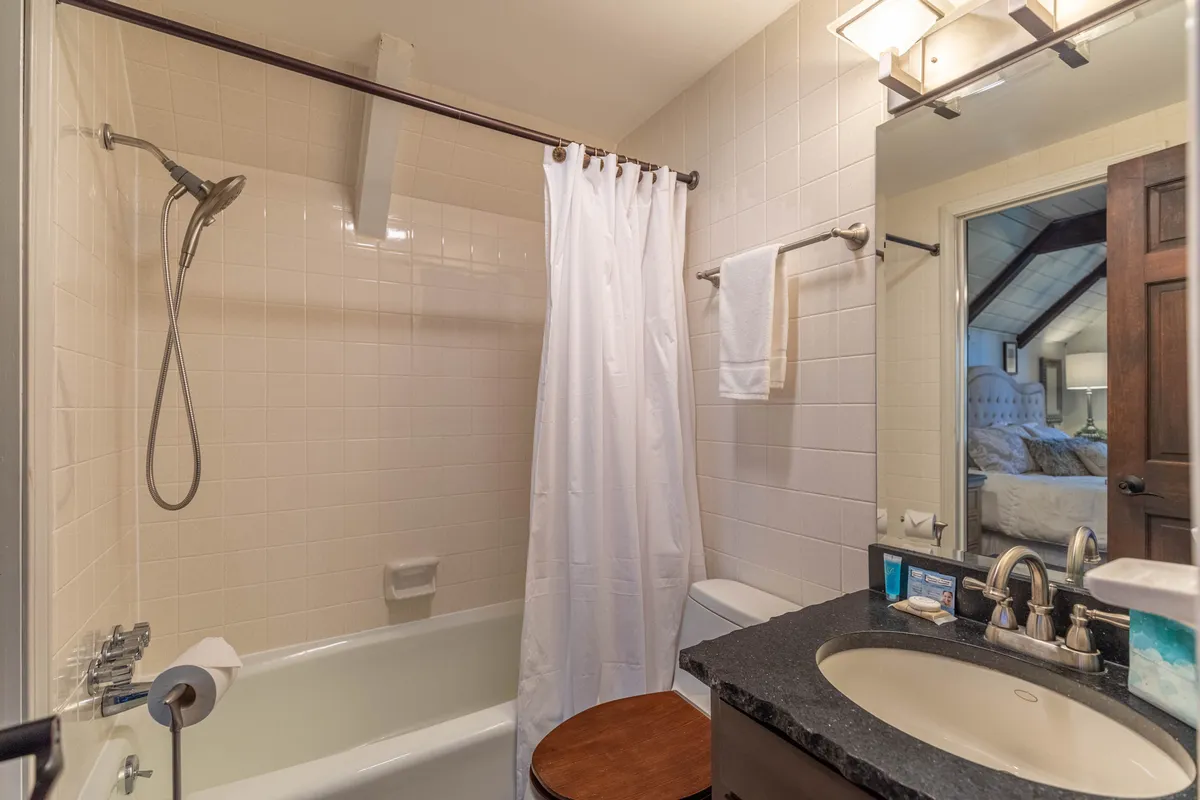 A modern bathroom with a spacious bathtub, sleek sink, mirror, and glass-enclosed shower, all arranged in a calm, inviting setting. The space suggests spa-like relaxation and thoughtful design.