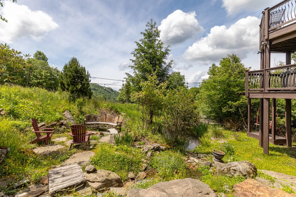 A tranquil outdoor fire pit area with wooden chairs and a natural landscape backdrop. The deck and fire pit evoke a sense of camaraderie and relaxation after a day of exploring.